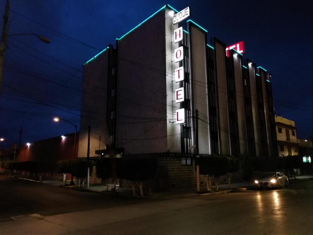 a building with a neon sign on the side of it at Hotel Duque in Mexico City