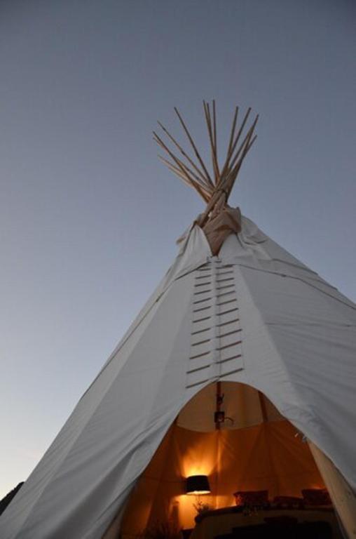 a white teepee with the sky in the background at Dreamcatcher Tipi Hotel in Gardiner