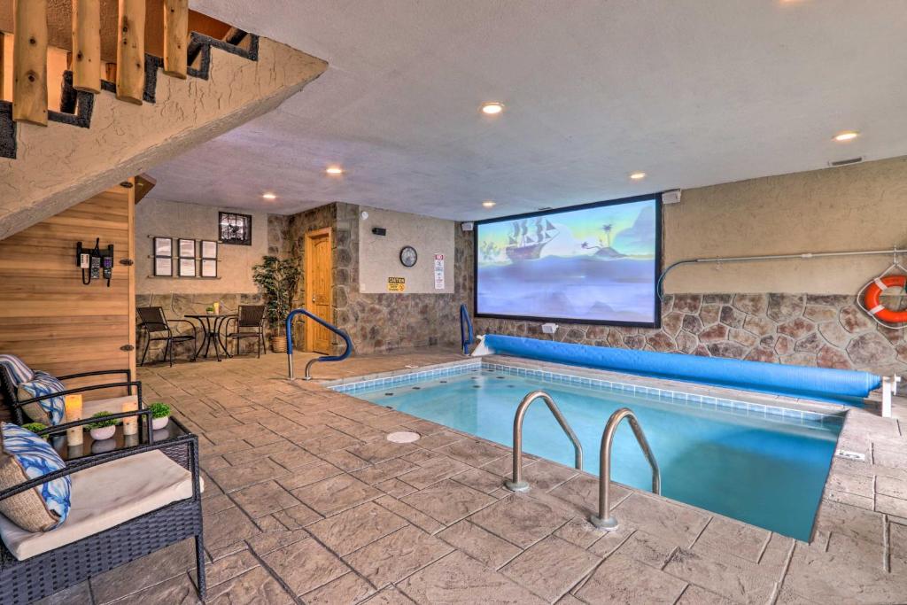 einen Pool mit einem TV in einem Hotelzimmer in der Unterkunft Luxe Smoky Mountain Cabin Indoor Pool and Fire Pit! in Sevierville