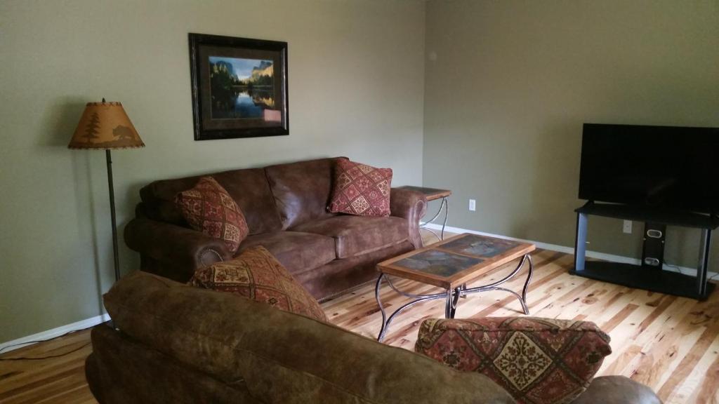 a living room with a brown couch and a table at Geyser Mountain Home in West Yellowstone