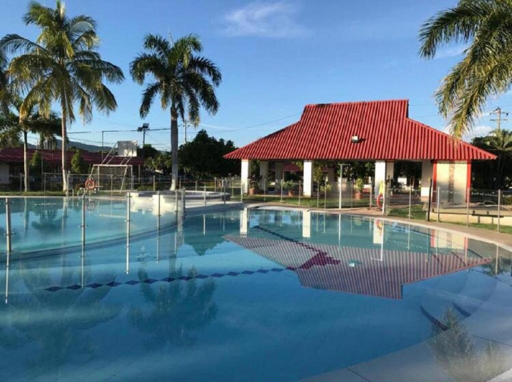 une piscine avec un bâtiment et des palmiers dans l'établissement Santa Mónica R&D by JR, à Flandes