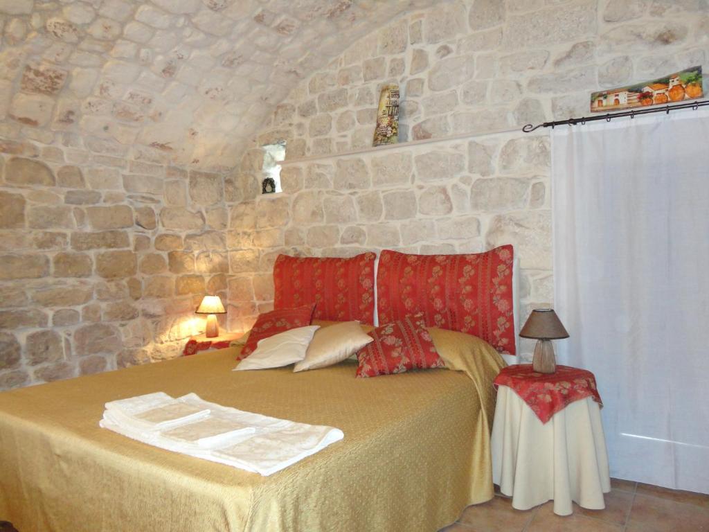 a bedroom with a bed with a stone wall at La Casa di Petra in Modica