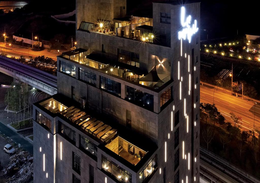 wysoki budynek z oświetleniem w nocy w obiekcie Lee Design Hotel w mieście Yongin