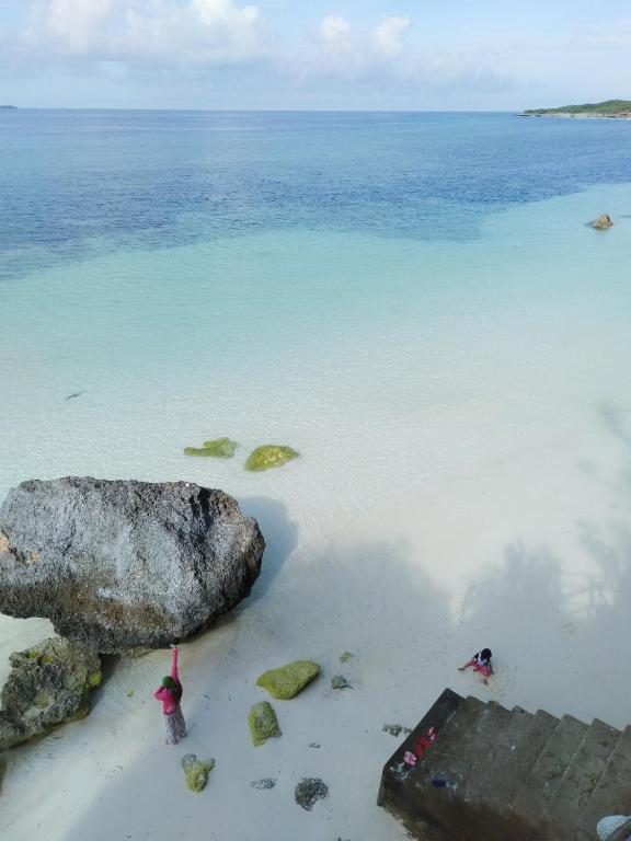 a large rock on a beach near the water at Bara Village Guest House Bira in Bira