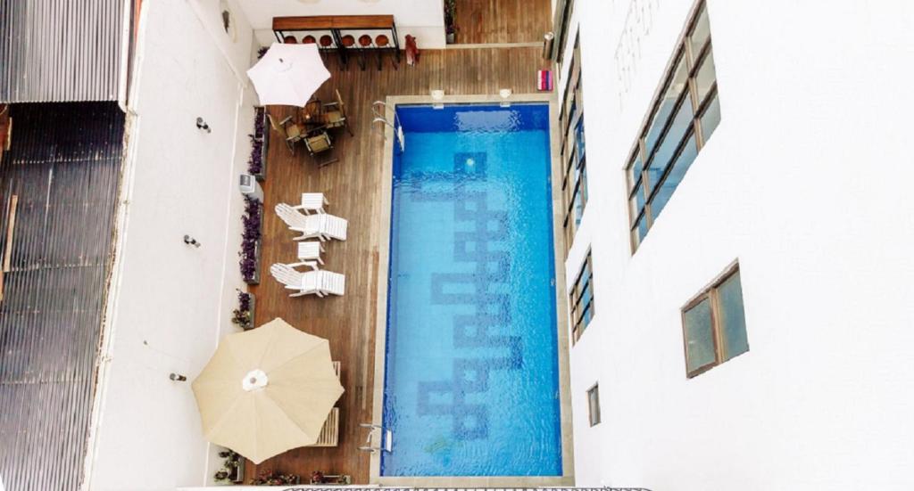 an overhead view of a swimming pool with an umbrella at Urbanest Inn House Slipi in Jakarta