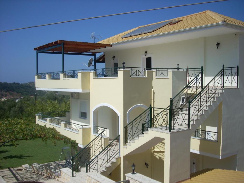 a large white building with balconies and stairs at Villa Vera in Syvota