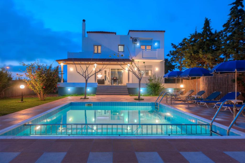 una piscina frente a una casa por la noche en Romantic Evas Cottage, en Gouves