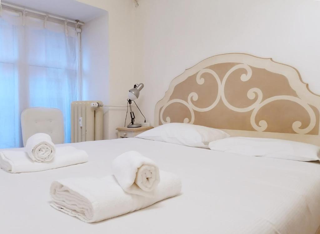 a bedroom with a white bed with towels on it at Porta Venezia & Giardini Montanelli Cozy Flat in Milan