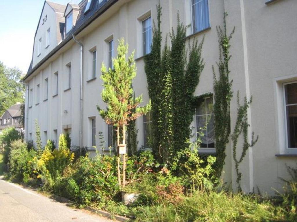 een gebouw met bomen en planten ervoor bij Feriendomizil Mikesh in Augustusburg
