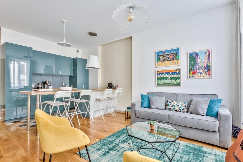 un salon et une cuisine avec un canapé et une table dans l'établissement Amazing 2 Rooms Flat near Bastille - An Ecoloflat, à Paris