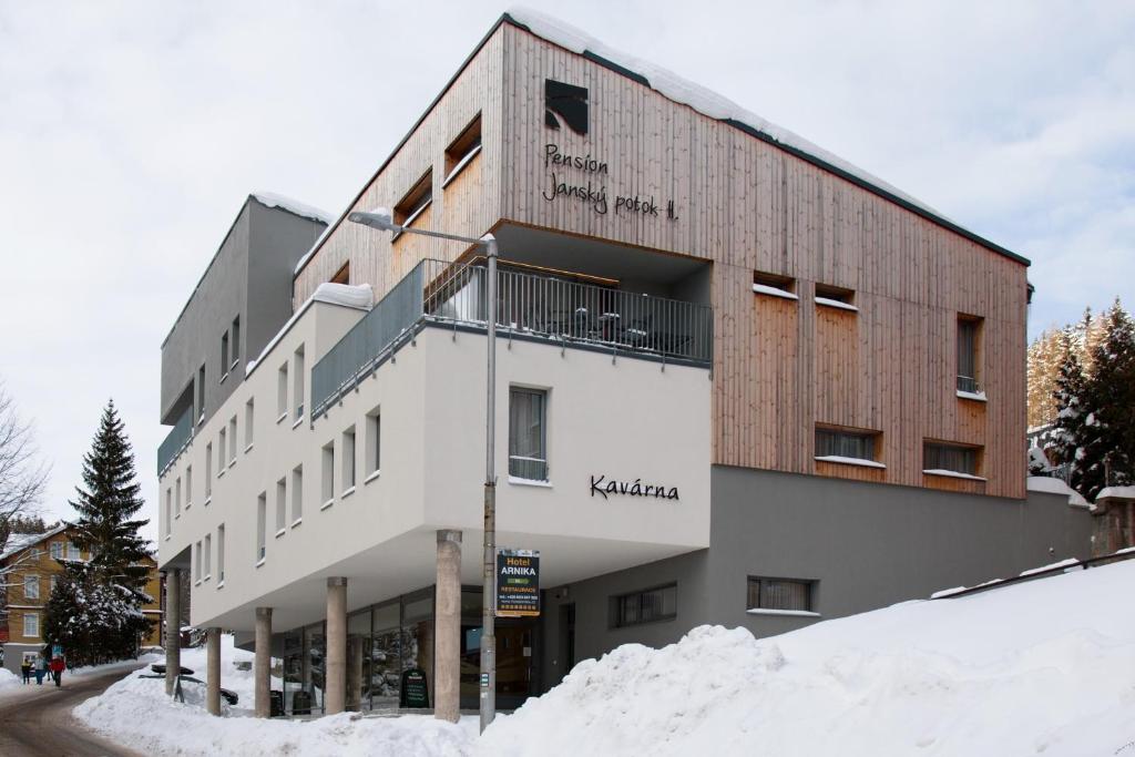 a building on a street with snow around it at Pension Janský Potok II. in Janske Lazne