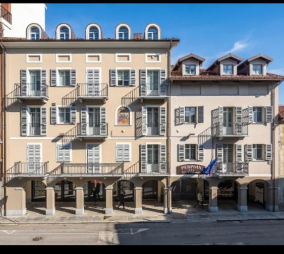 een groot gebouw met balkons aan de zijkant bij Hotel & Apartments " Perpoin " in Saluzzo