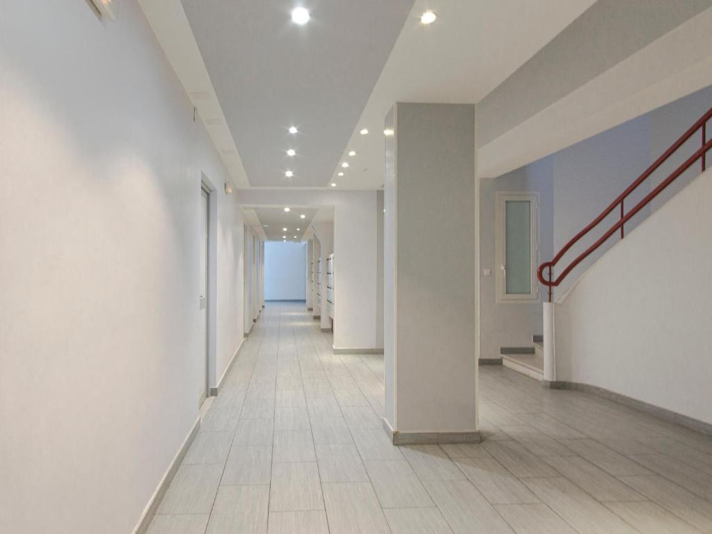 a hallway of an office building with white walls and a staircase at Studio climatisé à 50m des plages in Nice