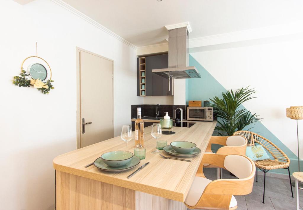 a kitchen with a wooden table and chairs at Studio climatisé à 50m des plages in Nice