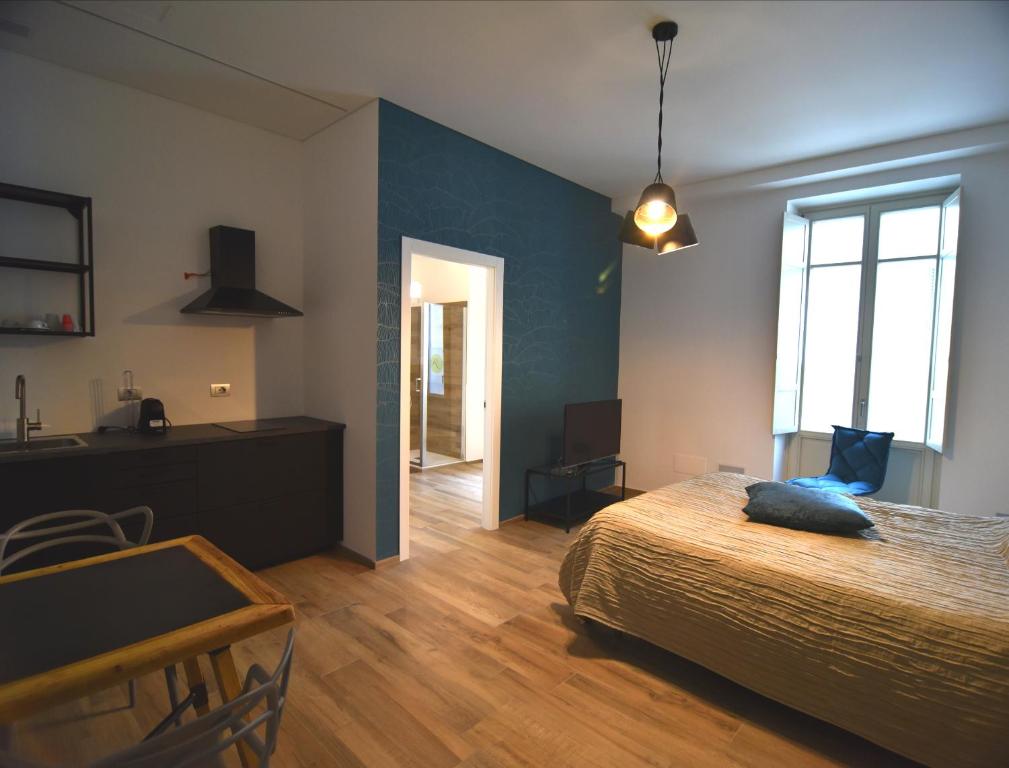 a bedroom with a bed and a desk and a window at Roma 141 in Fossano