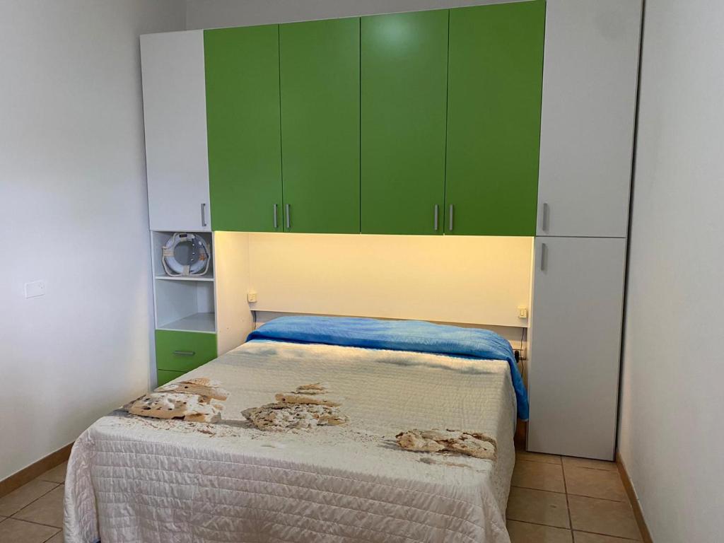 niewielka sypialnia z zielonymi szafkami i łóżkiem w obiekcie Villa Camelia By Cala Salento w mieście Torre Lapillo