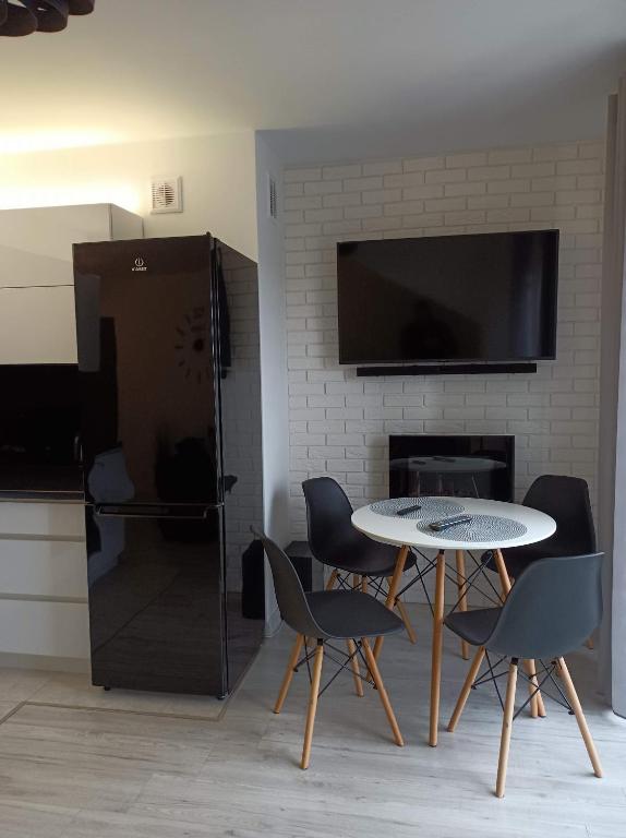 a kitchen with a table and chairs and a fireplace at Apartament Kruklanki in Kruklanki