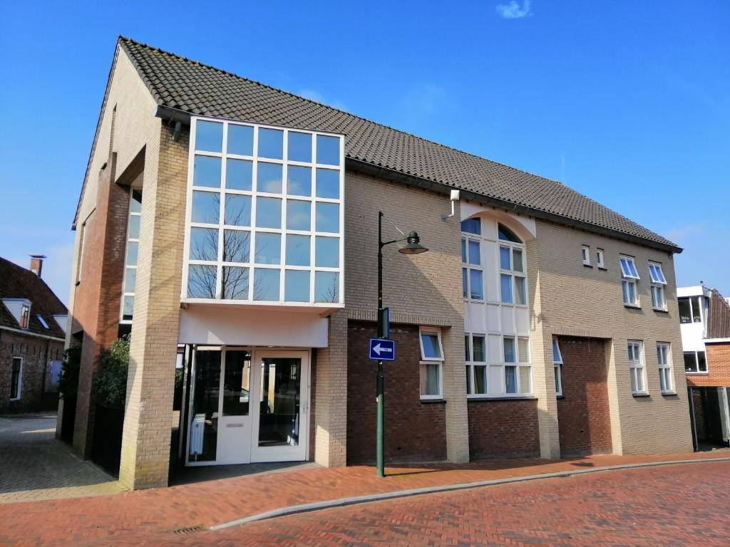 a large brick building with a large window at Logementen Dokkum in Dokkum