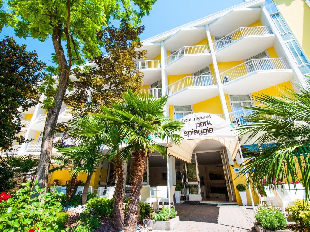 a hotel with palm trees in front of it at Hotel Park Spiaggia in Grado