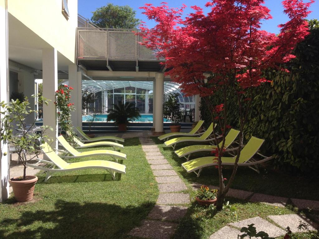 a row of chaise lounge chairs in a yard at Hotel Terme Belvedere in Abano Terme