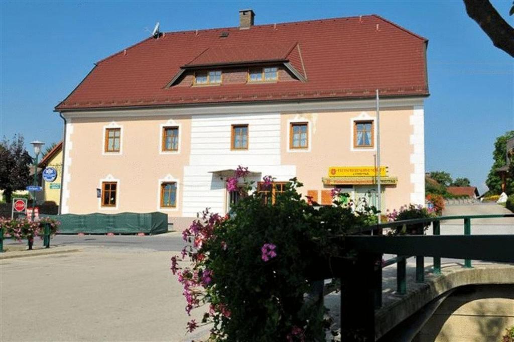 ein großes weißes Gebäude mit rotem Dach in der Unterkunft Gästehaus Freitag das kleine Hotel in Sankt Georgen