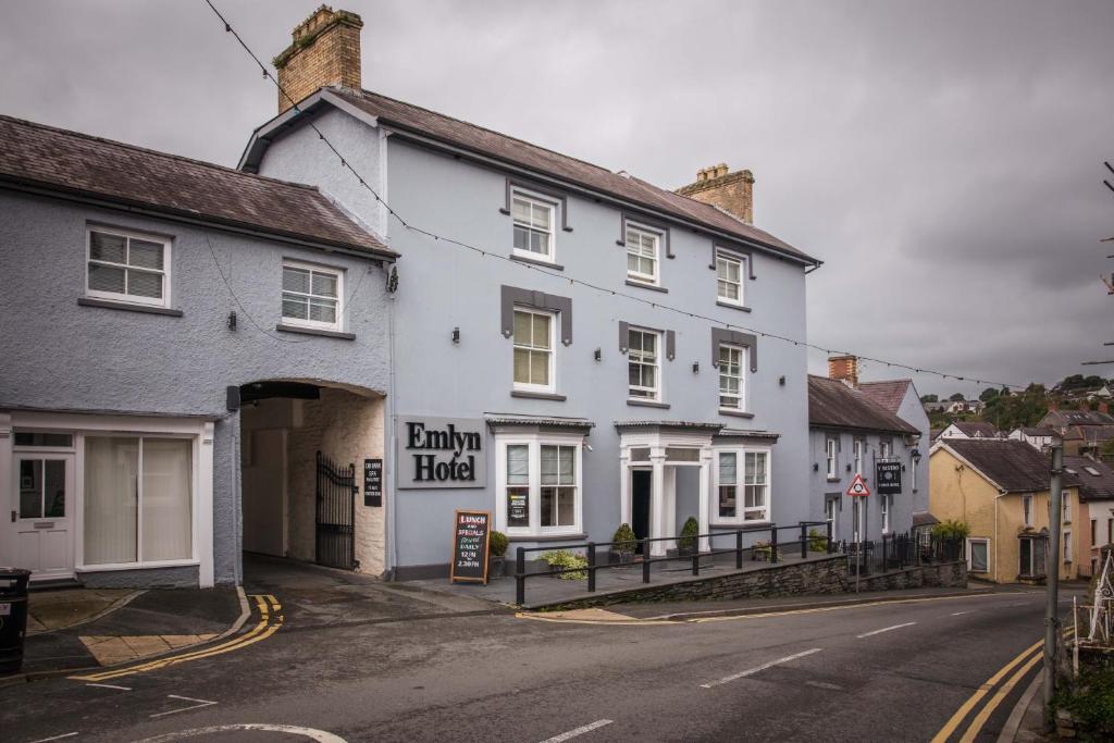 ein weißes Gebäude an der Straßenseite in der Unterkunft Gwesty'r Emlyn Hotel in Newcastle Emlyn