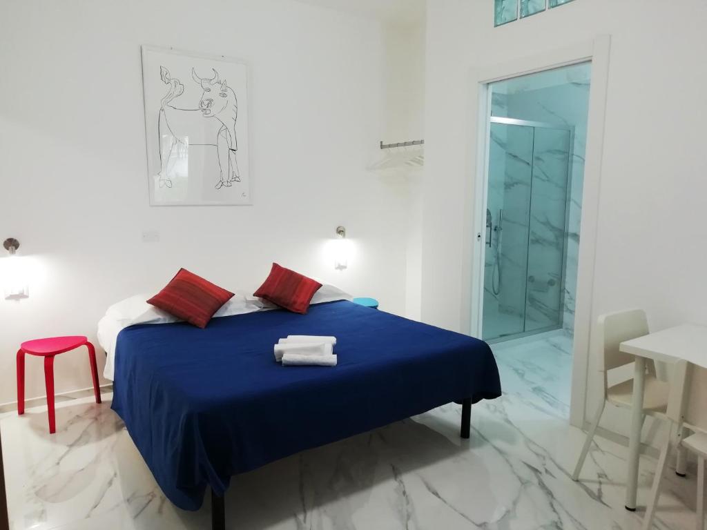 a bedroom with a blue bed and a glass shower at L'Altare Bianco in Vieste