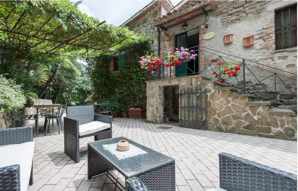 um pátio com uma mesa e cadeiras e um edifício em Casale Gli Angeli-Charming Villa with Garden and Parking! em Gubbio