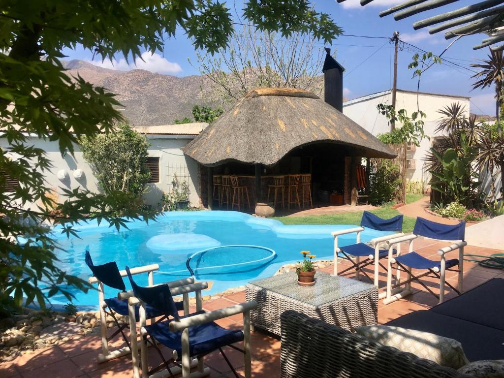 a pool with chairs and a table and a gazebo at John Montagu Accommodation in Montagu