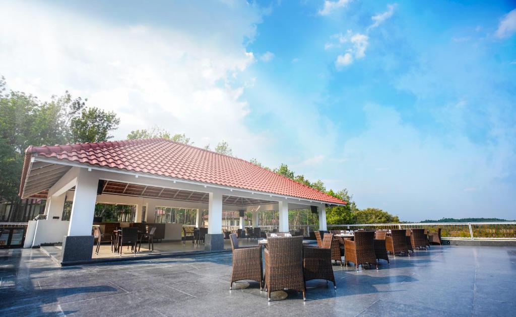 a pavilion with chairs and tables on a patio at Rosetta by Ferns in Sakleshpur