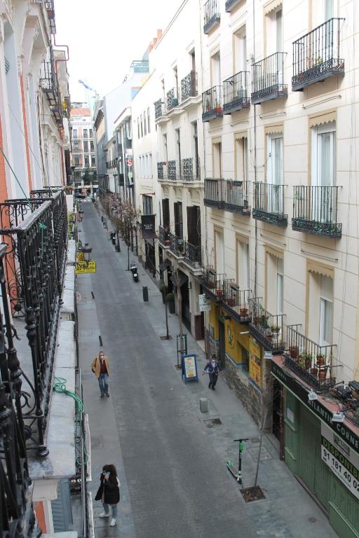 una calle de la ciudad con edificios y gente caminando por ella en Hostal Alfaro, en Madrid