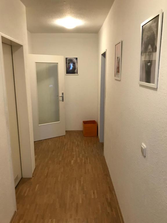 einen Flur mit Tür und ein paar Fotos an der Wand in der Unterkunft In the Middle of Hamburg City in Hamburg