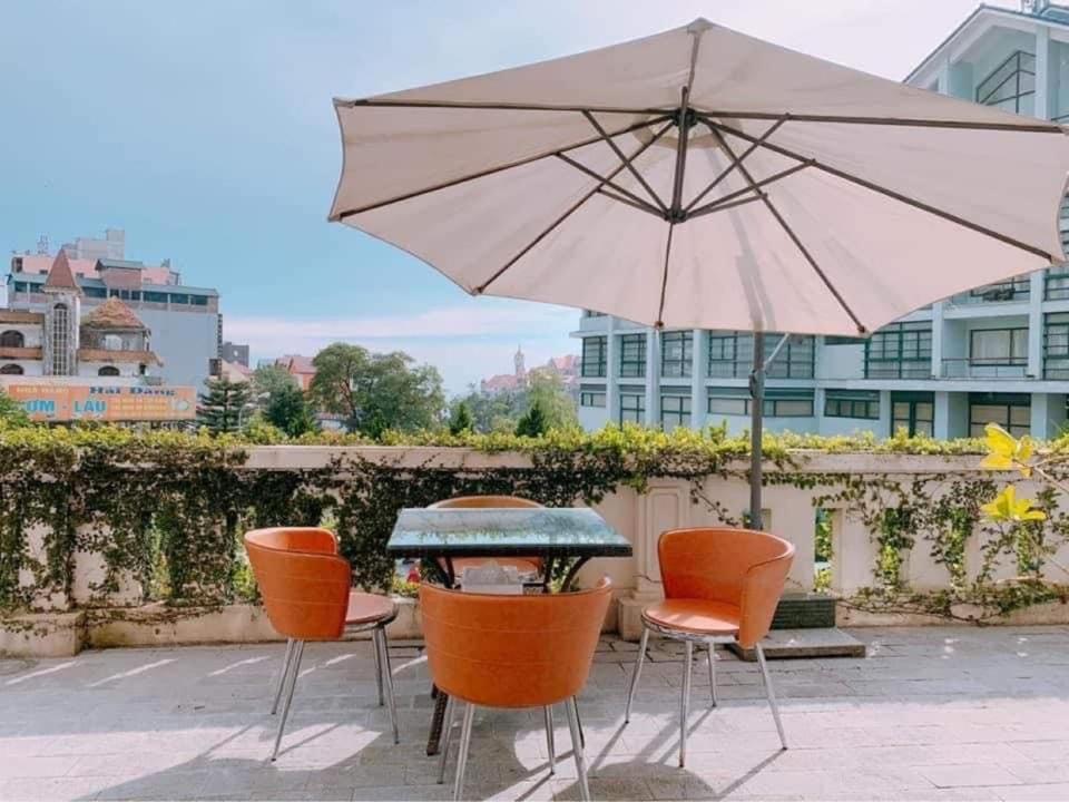 - une table et des chaises avec un parasol sur la terrasse dans l'établissement Hà Thành Tam Đảo HOTEL, à Tam Ðảo