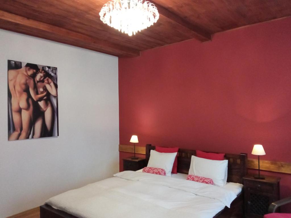 1 dormitorio con 2 camas y pared roja en Apartament Jonek, en Cracovia