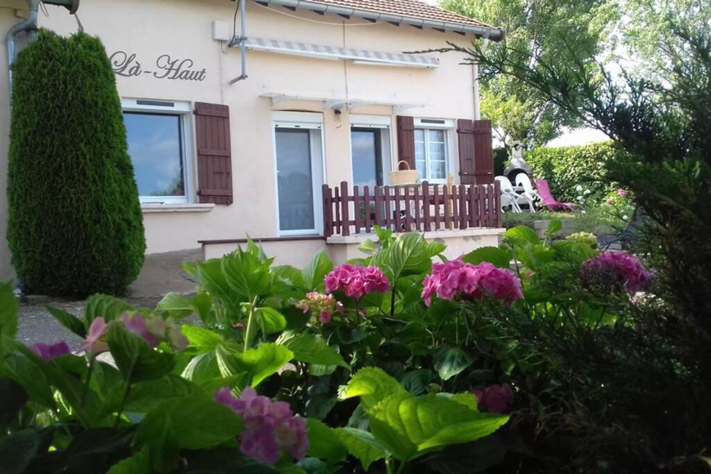 un jardín frente a una casa con flores en La-Haut, gite-maison de vacances, en Poinson-lès-Fays