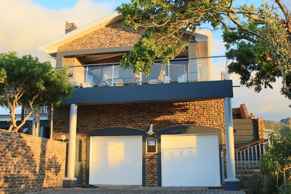 une maison en briques avec deux portes de garage blanches dans l'établissement Kleinmond - Fairview on First, à Kleinmond