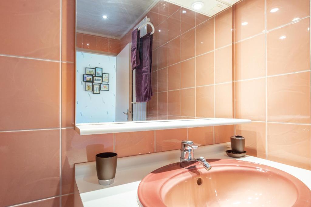 a bathroom with a sink and a mirror at Le Gréement - Appt vue sur le port in Courseulles-sur-Mer
