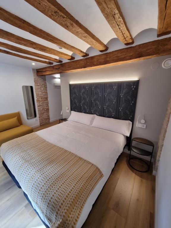Hostal La Rúa في إستيلا: غرفة نوم بسرير كبير وأريكة