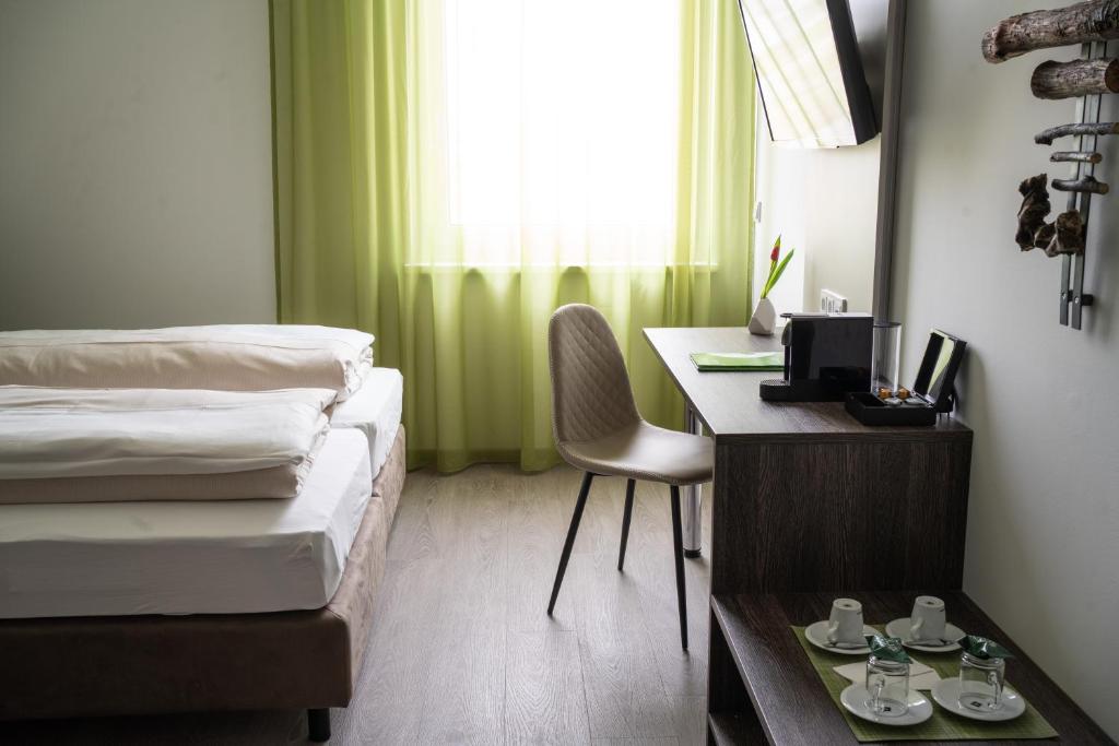 Neupirka的住宿－eee Hotel Graz，一间卧室配有一张桌子和一张床,一张桌子和椅子