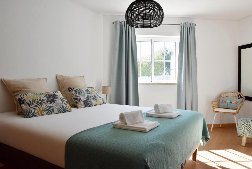 a bedroom with a bed with two towels on it at Doce Mar in Cabanas de Tavira
