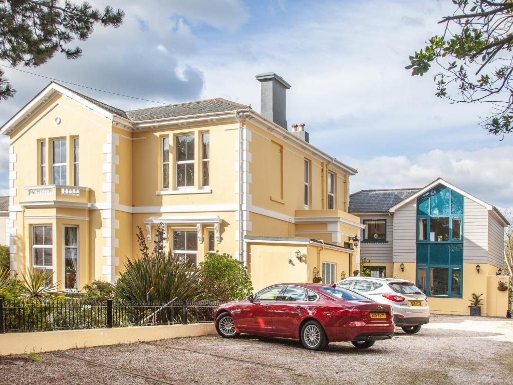 ein rotes Auto, das vor einem Haus parkt in der Unterkunft Court Prior Boutique B&B and Apartment in Torquay