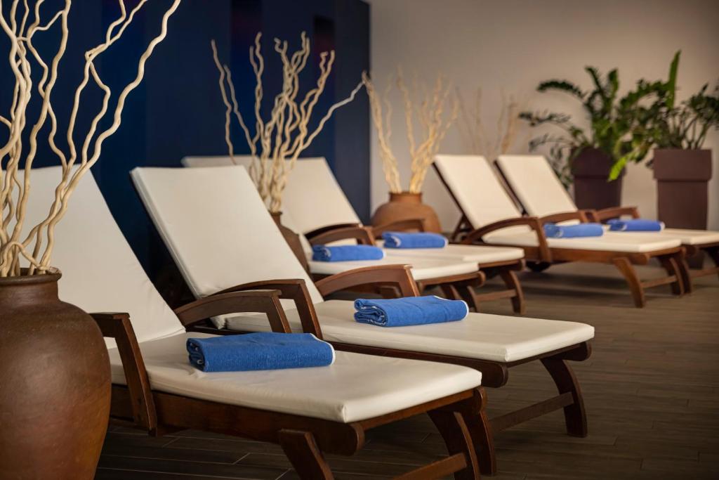 a row of chairs in a row with blue cushions at Valamar Diamant Hotel in Poreč