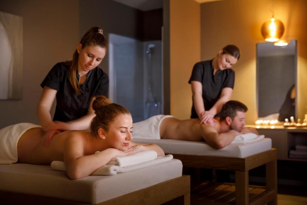 a couple of people laying on beds in a bathroom at Valamar Diamant Hotel in Poreč