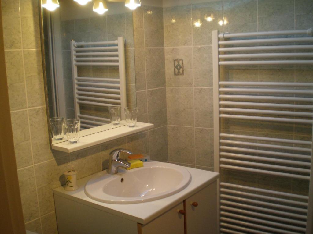 La salle de bains est pourvue d'un lavabo et d'un miroir. dans l'établissement Maison du Chapitel, à La Sauvetat