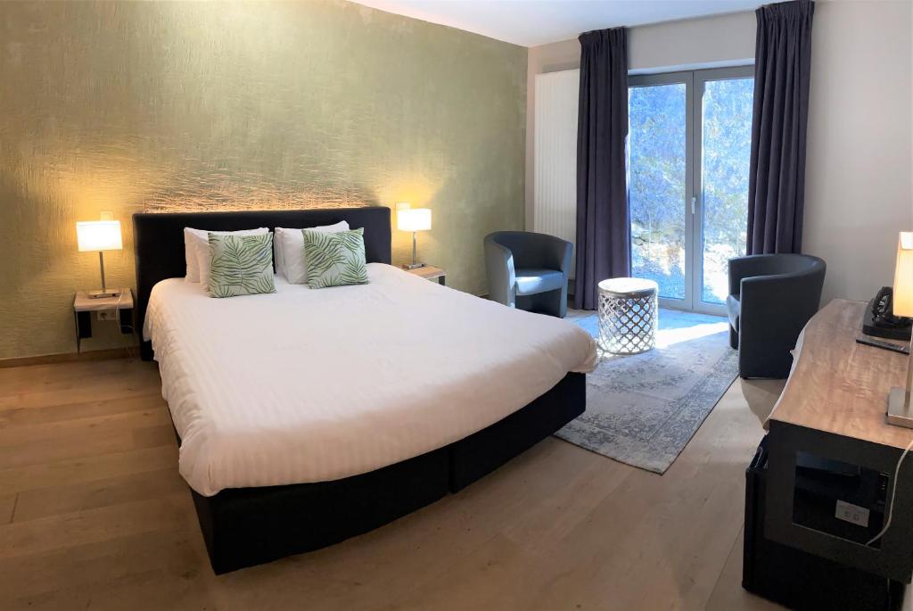 Postel nebo postele na pokoji v ubytování Hôtel WELLNESS EAU DE ROCHE Durbuy