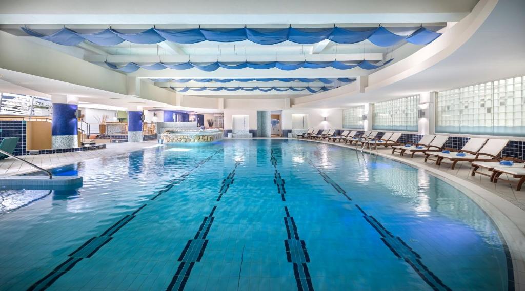 a large swimming pool with blue water in a building at Valamar Diamant Hotel in Poreč