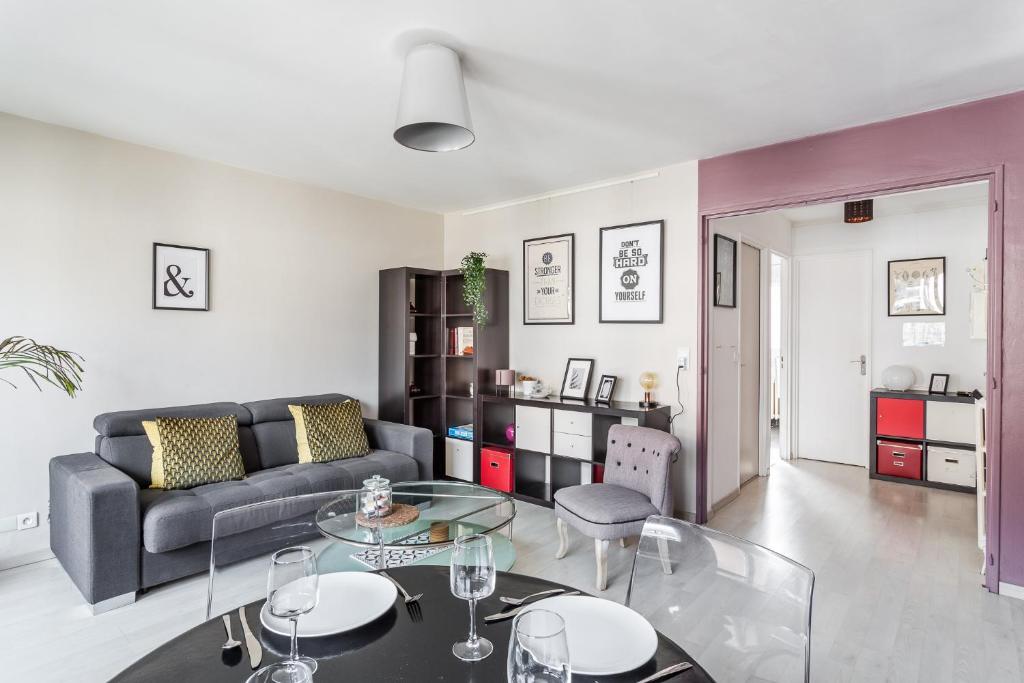una sala de estar con un sofá y una mesa en LORGERIL -appartement 2 chambres proche Mail, en Rennes