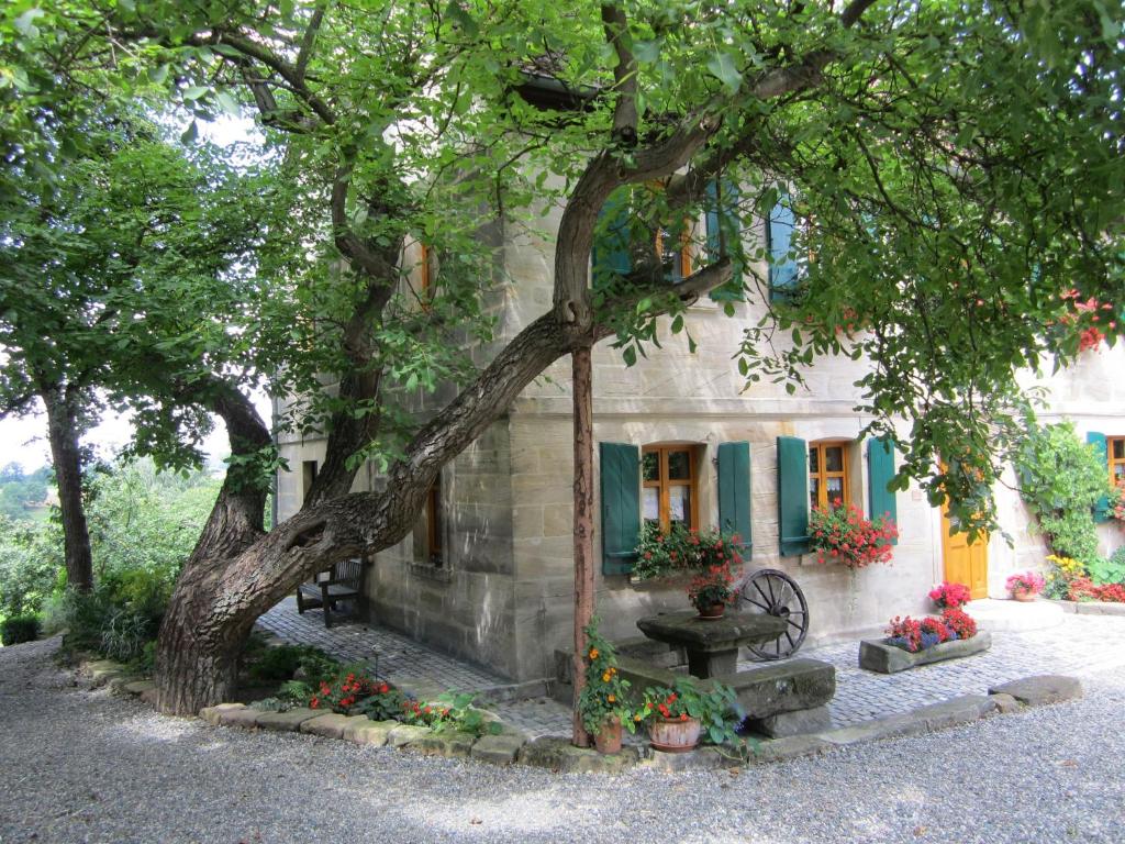 una casa de piedra con un árbol y una fuente en Das Landhaus en Mainleus