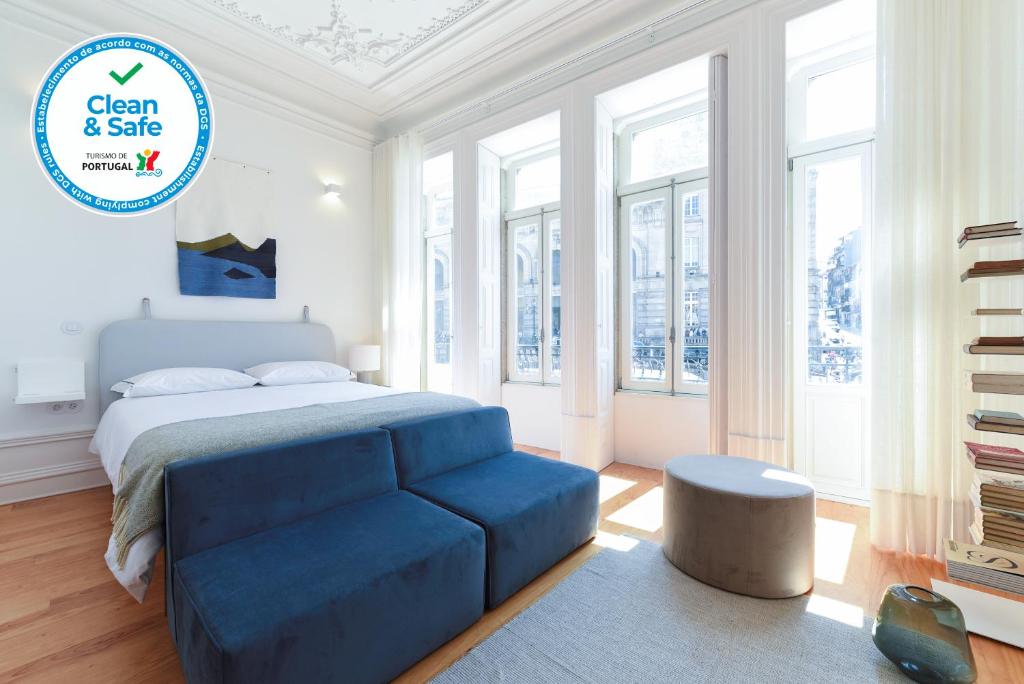 sypialnia z łóżkiem i niebieską kanapą w obiekcie Tripas-Coração, São Bento Apartments w Porto