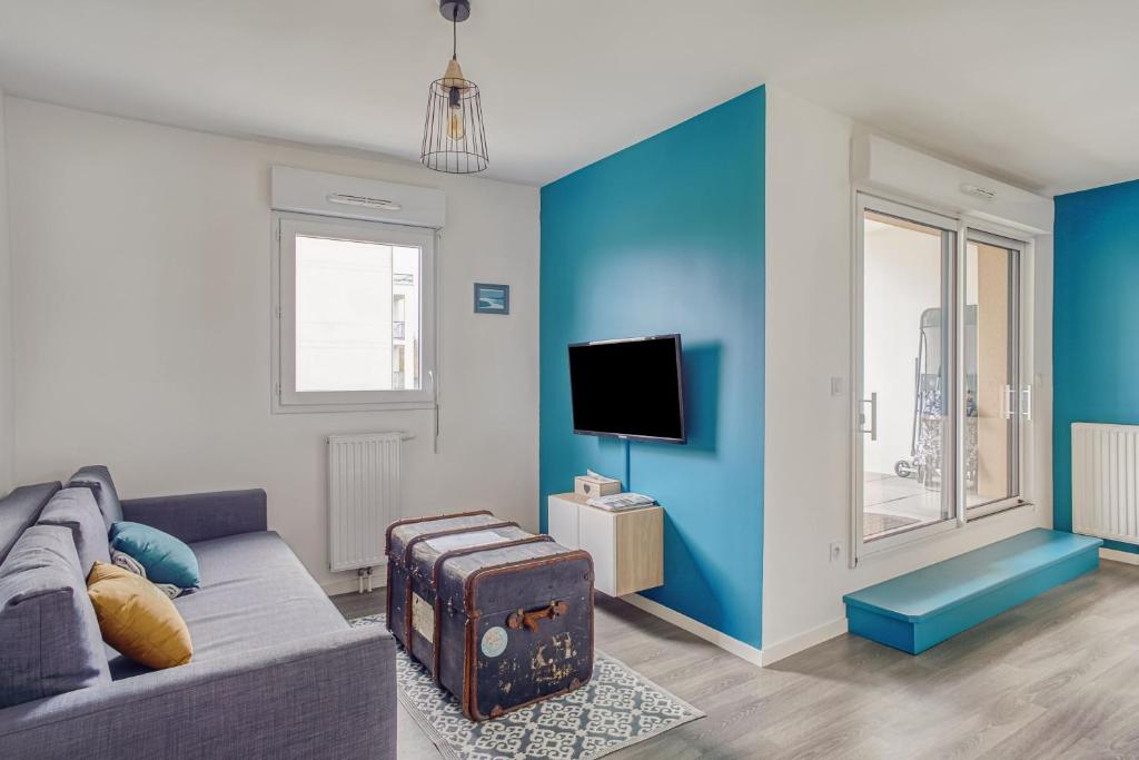 ein Wohnzimmer mit Sofa und Fernseher in der Unterkunft Ker Eno in Dinard